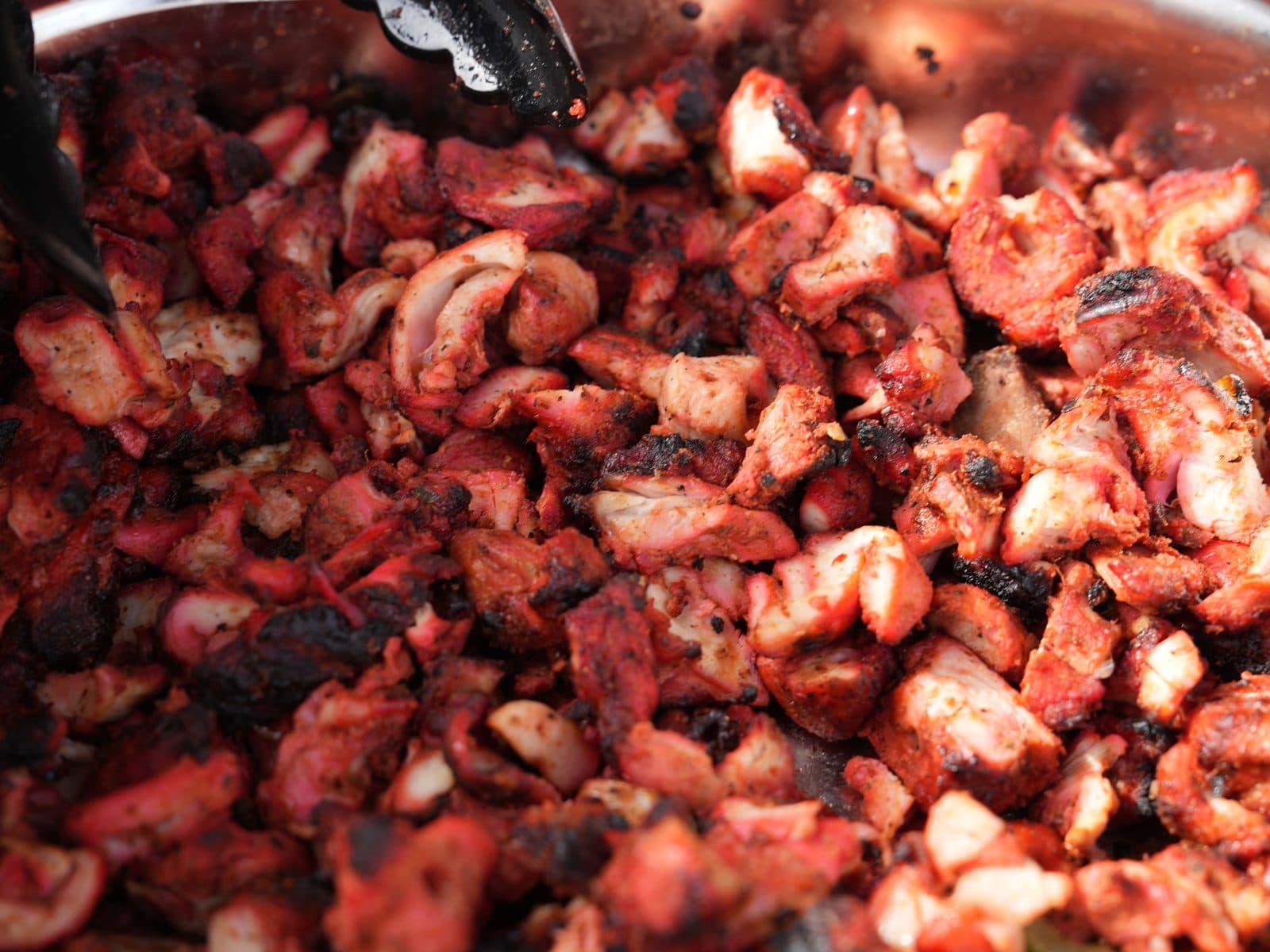 A pan piled high with chopped, char-edged tandoori chicken, straight off the grill and ready to go into wraps.