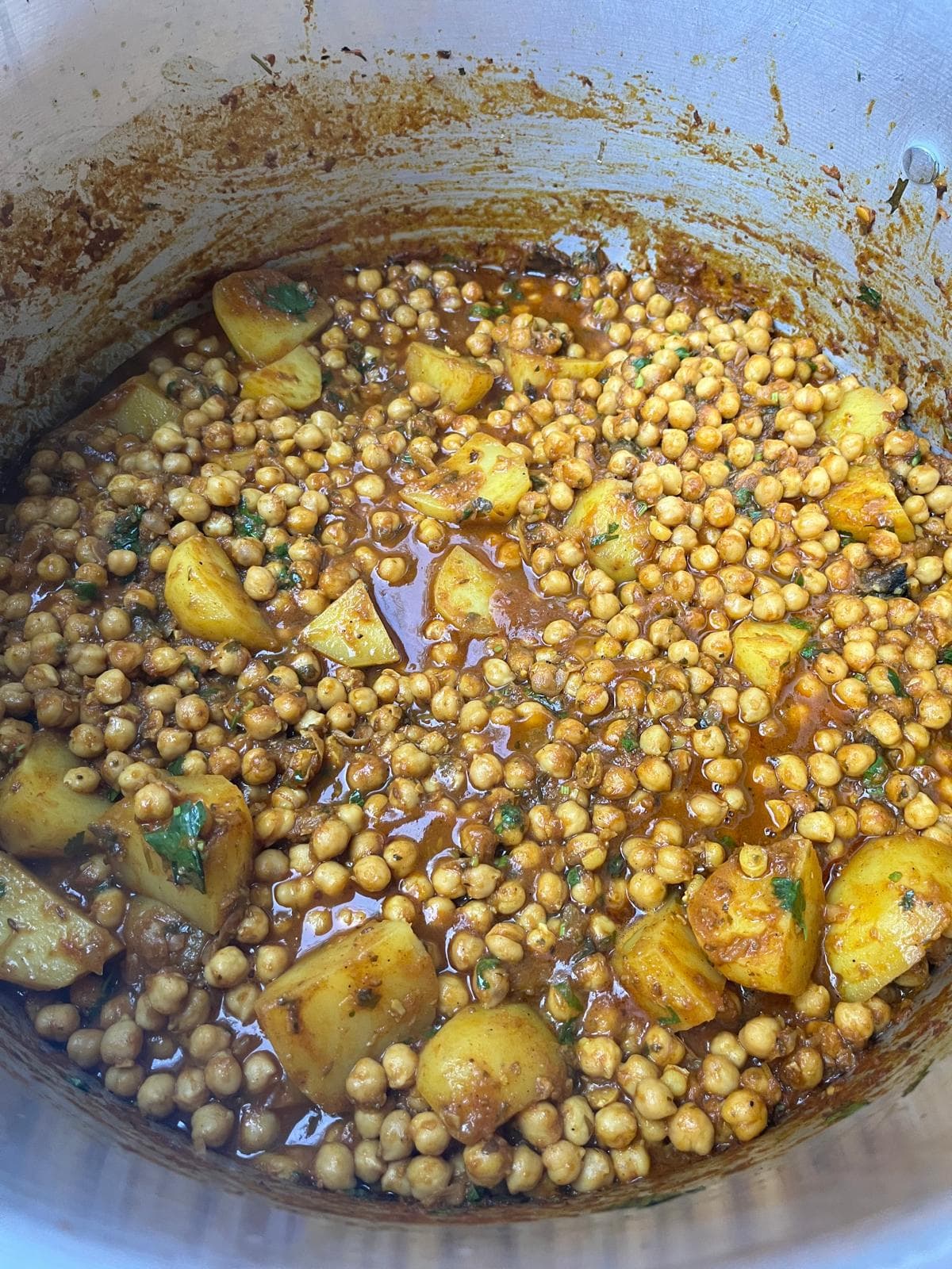 A potful of chole — chickpeas and potato in a dark spiced masala, finished with fresh coriander.